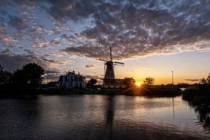 Coucher de soleil avec un moulin à vent néerlandais dans les eaux de Kralingse Plas, Rotterdam, Pays sur Tjeerd Kruse