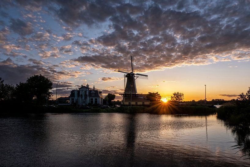 Sunset with Dutch windmill in the waters of Kralingse Plas, Rotterdam, Netherlands by Tjeerd Kruse