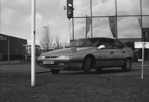 Een oude geparkeerde auto in zwart wit
