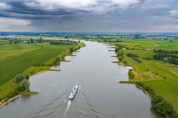 Bateau de marchandises sur la rivière Lek avec des nuages de pluie au-dessus