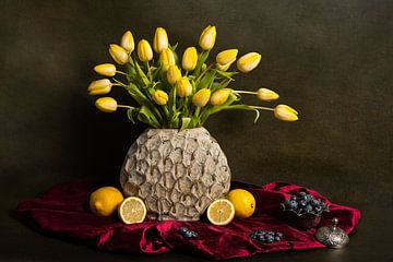 Stilleven met gele tulpen, citroenen en blauwe bessen op een rood tafelkleed