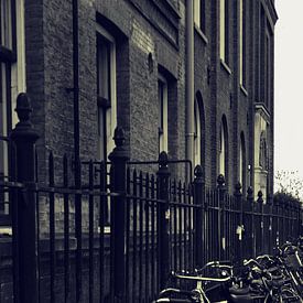 fietsen langs hek Amsterdam van Miranda Auwens