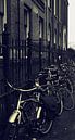 fietsen langs hek Amsterdam van Miranda Auwens thumbnail