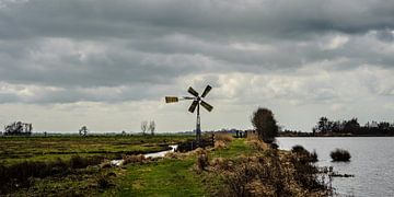 Polderlandschap met dijk, windmolen en waterpartij van Dirk Huckriede