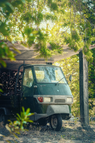 Een groene oldtimer Piaggio Ape in Toscane Italië.
