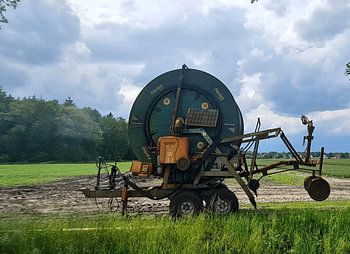 A sprinkler reel under threatening skies