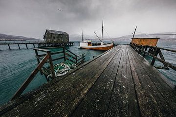 Wooden dock with boat by Martijn Smeets