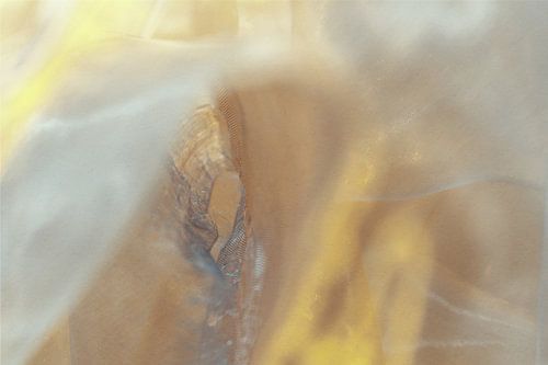 Interwoven light - golden-brown layers of fabric in motion