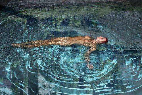 naakte vrouw in helder blauw water met reflectie van omgeving