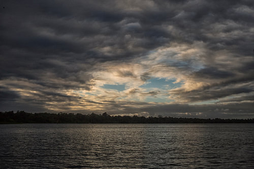 Zonsondergang en wolken boven de rivier