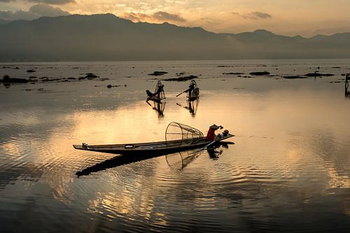 PÊCHEUR AT SUNRISE vist ON WAY TRADITIONNEL AU LAC INLE AU MYANMAR. Avec un panier du poisson est ca