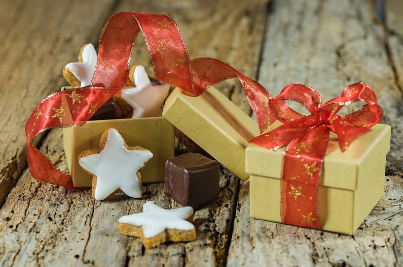 Weihnachtsstern Kekse und Schokolade Geschenk mit roter Schleife auf Holztisch von Alex Winter