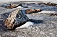 Gefrorener Fluss mit Steinen