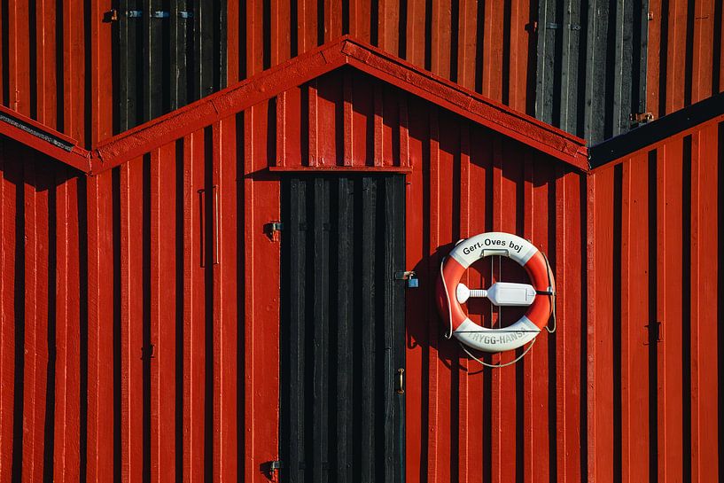 Lifebuoy on a red wooden house in Sweden by Martijn Smeets