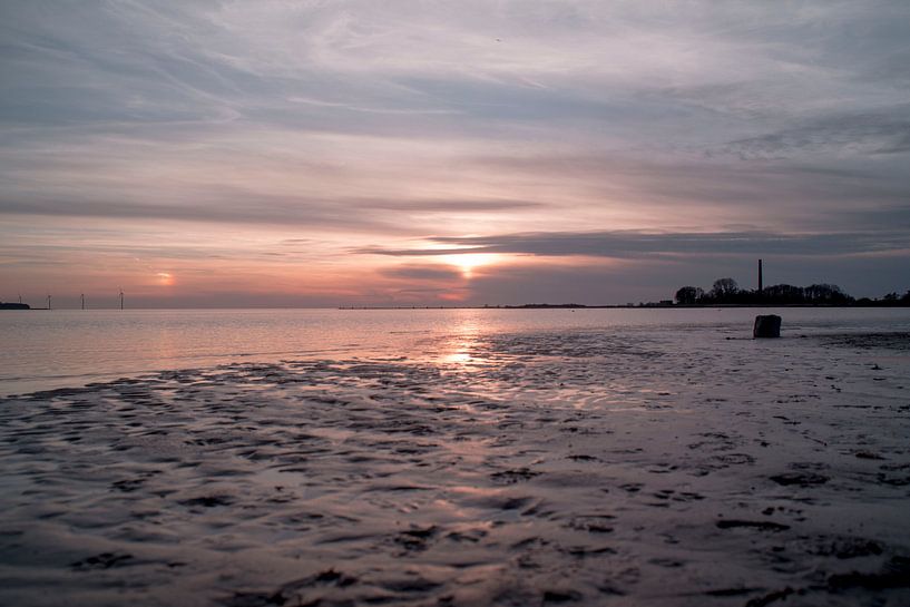Beautiful sunset with reflection on the sand by Jolien Kramer