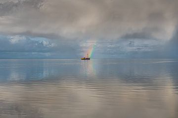 Vissersboot op een spiegelend  Wad met een wolkenlucht