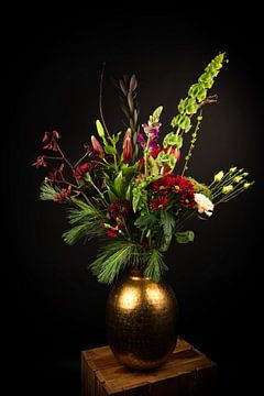 Strauß roter Blumen in einer goldenen Vase