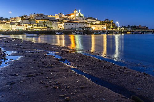 Zandstrand in de ochtend met uitzicht op het historische centrum van Ferragudo, Portimão, Algarve, Portugal