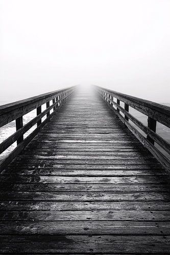 Lange houten pier in mist