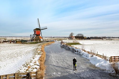 Schaatsen in Hollands polderlandschap met uitzicht op een historische wipmolen.