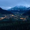 Bergtal am Abend mit Lichtern und Gipfeln im Schnee von Jens Sessler