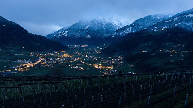 Bergtal am Abend mit Lichtern und Gipfeln im Schnee von Jens Sessler