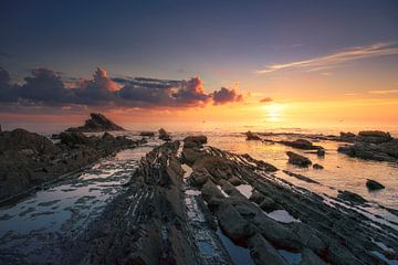 Rocks in the sea at sunset in Livorno, Tuscany by Stefano Orazzini