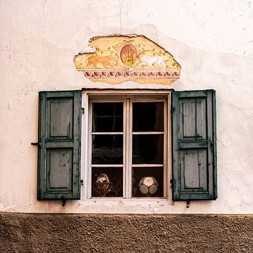 Karakteristiek oud raam met blauwe luiken en een muurschildering van Dafne Vos