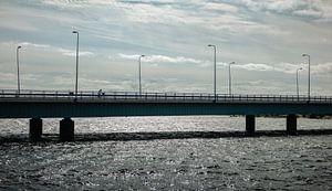 Linie über dem Wasser – Brücke mit Radfahrer & Lichtreflexen