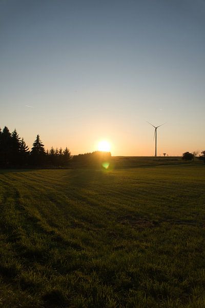 Windturbine bij zonsondergang op een weiland van Martin Köbsch