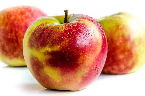 3 Pommes Jonagold fraîches et juteuses, assiette libre sur blanc