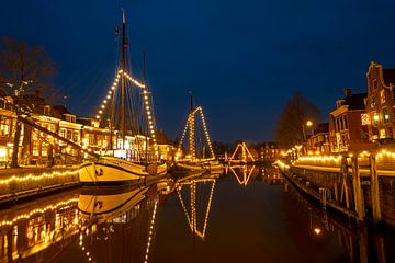 Geschmückte Boote im Hafen von Dokkum in den Niederlanden in der Nacht zur Weihnachtszeit von Eye on You
