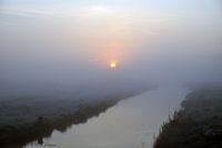 rising sun in the mist