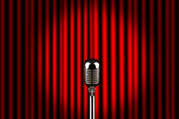 Een microfoon op een podium voor een rood gordijn van Jörg B. Schubert
