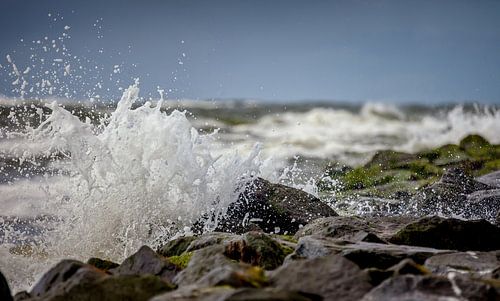 Ruige zee met opspattend water op de golfbrekers van Texel