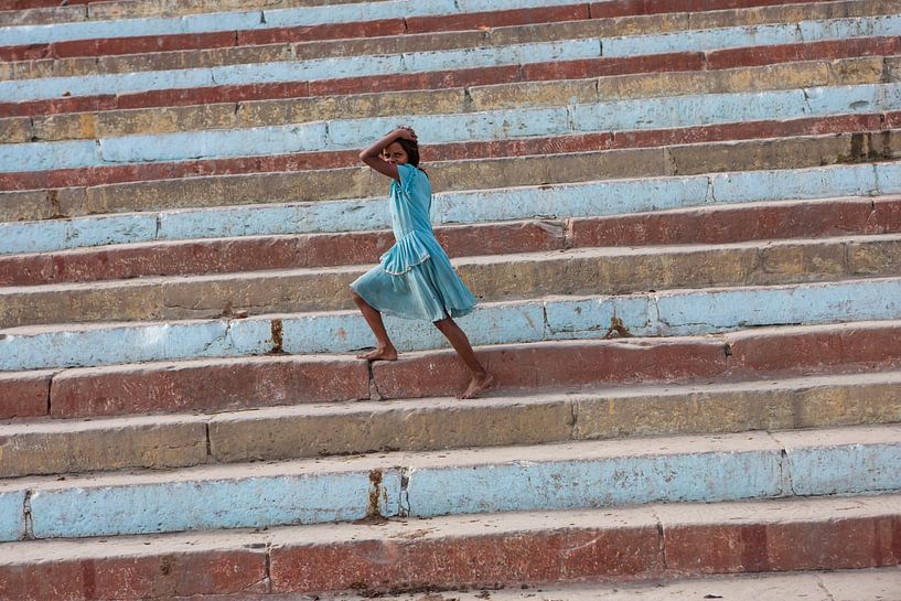 Meisje loopt op een gekleurde trap aan de oever van de Ganges in Varanasi India van Wout Kok