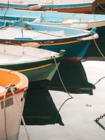 Coloured fishing boats in the port of Procida reflecting in the sea