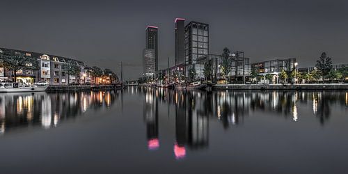 Die Skyline des Leeuwardener bei Nacht im stillen Wasser gespiegelt.