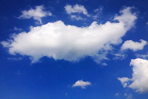 Weiße Kumuluswolken vor azurblauem Himmel