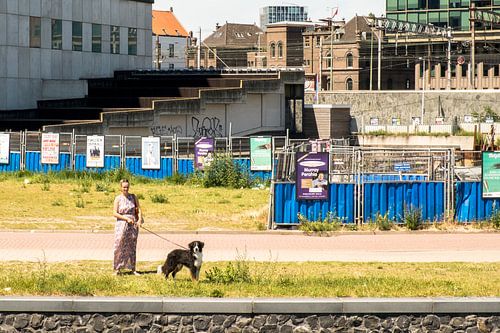 Vrouw met hond aan de kade