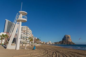 Het strand met uitkijktoren en rots (La Puntera) bij Calp, Alicante in Spanje van Joost Adriaanse