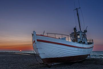 Visserboten op het Deense strand bij zonsondergang.