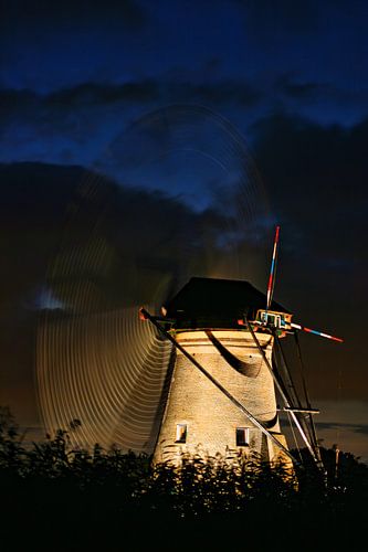 Kinderdijk molen bij ondergaande zon. Tijden de verlichte week met draaiende wieken