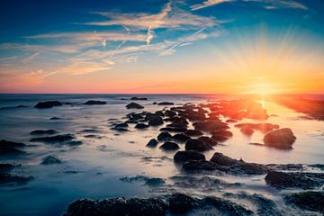 sunset along the North Sea with a typical breakwater in the foreground by gaps photography