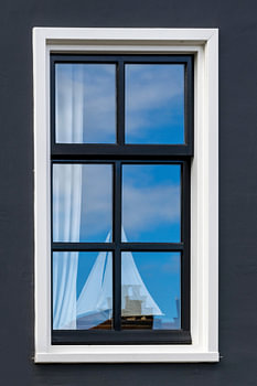 Dutch Window with a Reflection of the Sky and a Sailboat