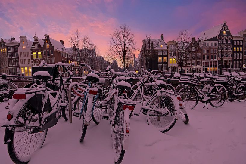 Besneeuwd Amsterdam bij zonsondergang in de winter van Eye on You