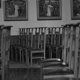 Kerkstoelen in een kerk. van Kim De Sutter