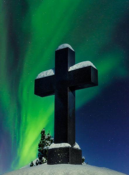 Polarlichter und ein schneebedecktes Kruzifix auf einem Friedhof von ManfredFotos