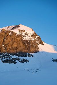 Bergbeklimmers onder bergtop in het ochtendlicht van Joep van de Zandt