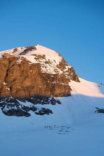 Mountaineers under mountaintop in morning light by Joep van de Zandt